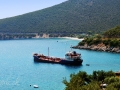 Loď, ktorá preváža sladkú vodu na ostrov Spetses, za ňou pláž Krioneri.