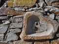 Pyrgos, Tinos, reliéf z mramoru vsadený do kamenného múra